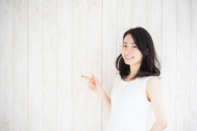 beautiful young woman against white wooden wall