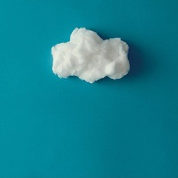 cloud made out of cotton wool on blue background. flat lay. weather concept.