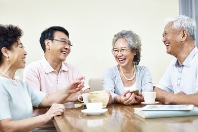 small group of senior asian people getting together talking and laughing