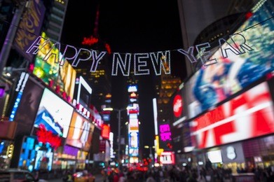 glittery happy new year message strung across the flashing lights of times square, new york city