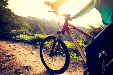 riding mountain bike at sunrise forest trail