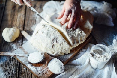 close up view of baker kneading dough. homemade bread. hands preparing bread dough on wooden table. preparing traditional homemade bread. woman hands kneading fresh dough for making bread
