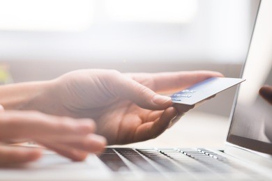 hands holding credit card, typing on the keyboard of laptop, onine shopping detail close up