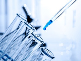 pipette adding fluid to one of several test tubes .medical glassware