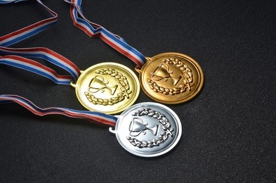 gold, silver and bronze medals on top of black board