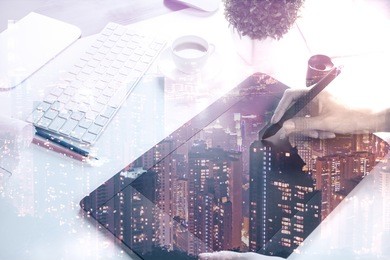 female hands using digital pad at workplace with abstract city view. double exposure