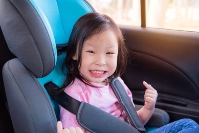 young asian girl smiling on the car with safety belt