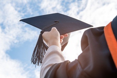 graduates of the university,of graduates holding hats handed to the sky.