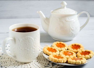  teapot, cup of tea and biscuits on the wooden table