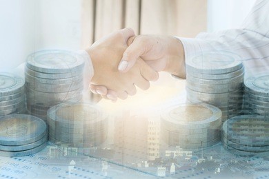double exposure of two business people handshake and coin on book bank, city. success concept