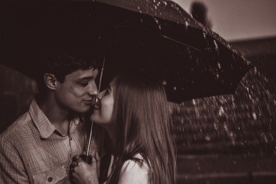 love in the rain / silhouette of kissing couple under umbrella
