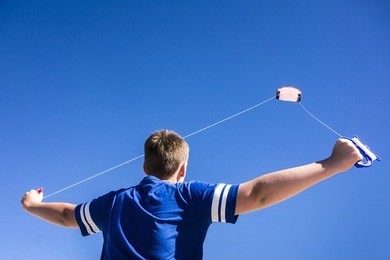 child flying a kite in the clear blue sky.