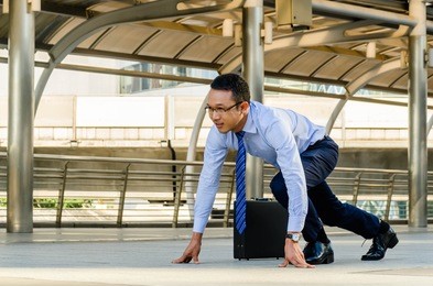 young smart determined asian businessman standing in start position runner and ready to go , business competition concept.