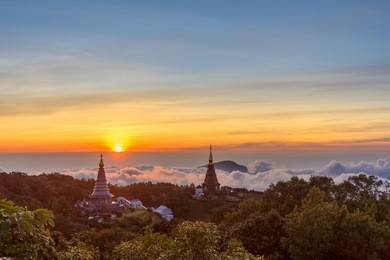 landscape of two pagoda (noppha methanidon-noppha phon phum siri stupa) in sunrise time with mist in the backgroundat at inthanon mountain, chiang mai, thailand