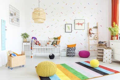 baby room with white wall and light wooden furniture