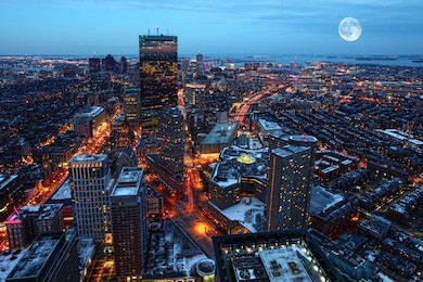 a rising moon over the city of boston