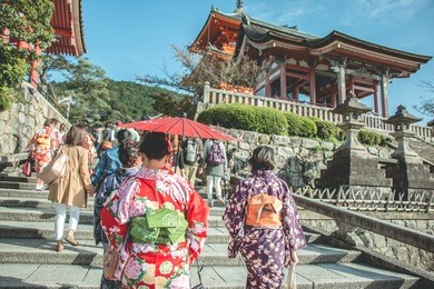 3 woman wear red yukata or kimino walk up stairs to kiyomizu dera, temple gate , kyoto, japan.
