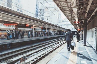 businessman arriving at the train station in the morning sunlight and going to work in the city. selective focus, vintage photo and film style.