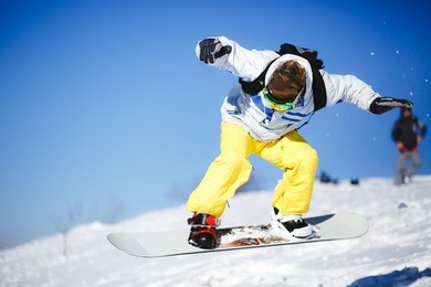 snowboarder jump from wooden springboard in the mountains