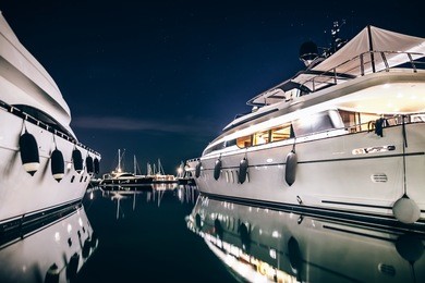 luxury yachts in la spezia harbor at night with reflection in water. italy
