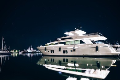 luxury yachts in la spezia harbor at night with reflection in water. italy