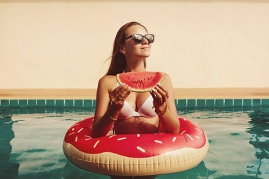 fashion woman wearing sunglasses with red watermelon enjoy in swimming pool with red rubber ring