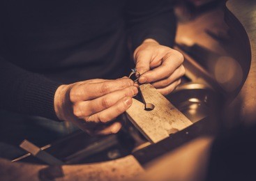 jeweler at work in jewelery workshop.
