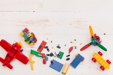 top view on colorful toy bricks on a white wooden background. toys in the table