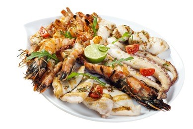 a variety of seafood grill on a large platter. king prawns, crab phalanges, scallops, langoustines, octopus