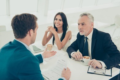 two happy colleagues on meeting with their business partner