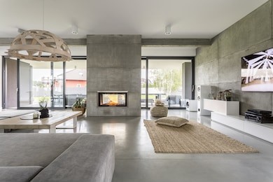 spacious villa interior with cement wall effect, fireplace and tv