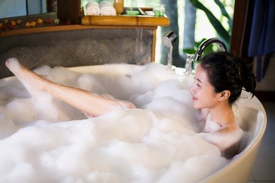 women was bathing in a a bathtub with happiness.