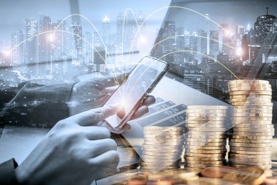 double exposure of businessman investor using smart phone at office with city night and step of coins background, ,on-line banking and investment concept