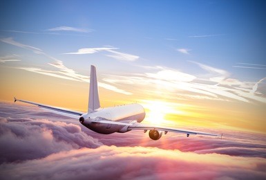 commercial airplane flying above clouds in dramatic sunset light. very high resolution of image