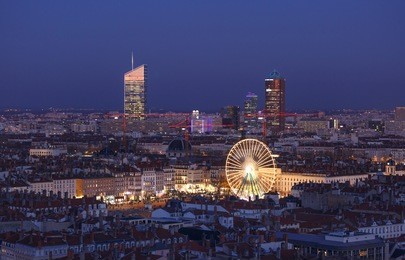 ferris wheel with smiley on square place bellecour in lyon, france, during twilight.