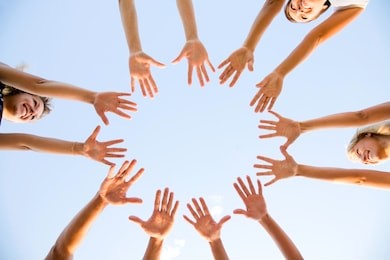 hands of young people stretching to the center