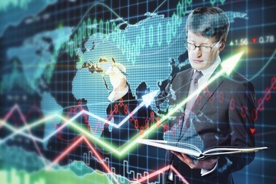 handsome businessman with notepad on forex chart background. economy concept