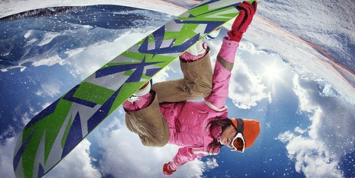 sports background. snowboarder jumping through air with deep blue sky in background. fish eye.