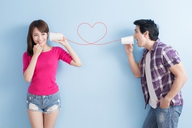 young couple with can phone isolated on blue background