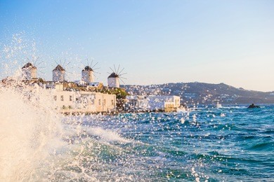 famous view of traditional greek windmills on mykonos island at sunrise, cyclades, greece