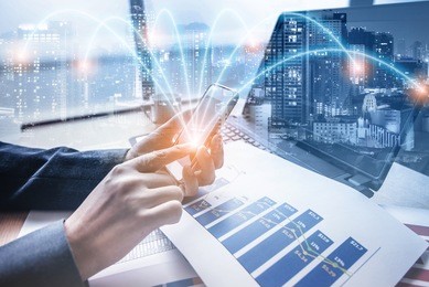 double exposure of businessman using smart phone at office with city night background, network connection concept 