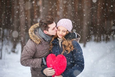 couple in the forest in winter, walk, kiss, hug and hold hands heart