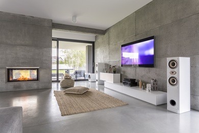 tv living room with window, fireplace and concrete wall effect