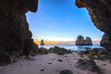 a cave arch by the sea at sunrise