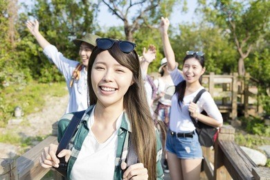 happy young group hiking together through the forest
