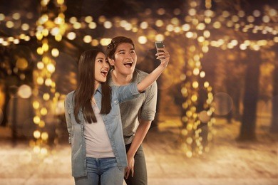 happy asian couple in love taking selfie photo with smartphone