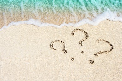 question mark sign handwritten in sand beach