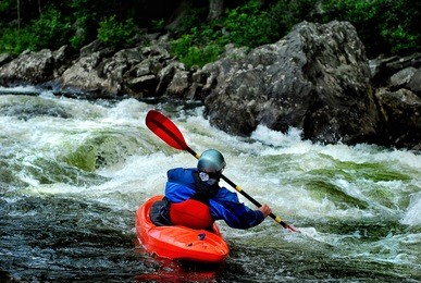 a whitewater kayaker braces in fast moving water on the river