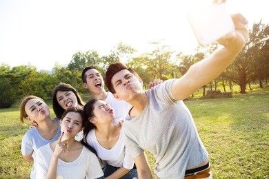 happy young group taking selfie in the park