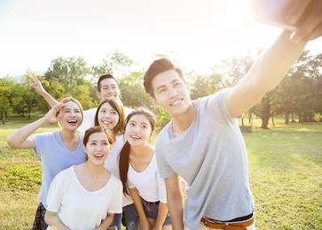 happy young group taking selfie in the park